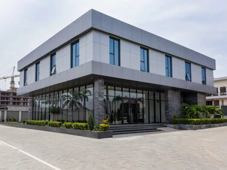 Two-storey prefabricated office building — corporate headquarters with ACP cladding and glass curtain wall entrance, Nigeria