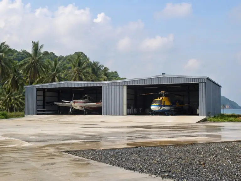 Metal aircraft hangar — prefab steel agricultural aviation structure with sliding door for crop-dusting fleet, Southeast Asia