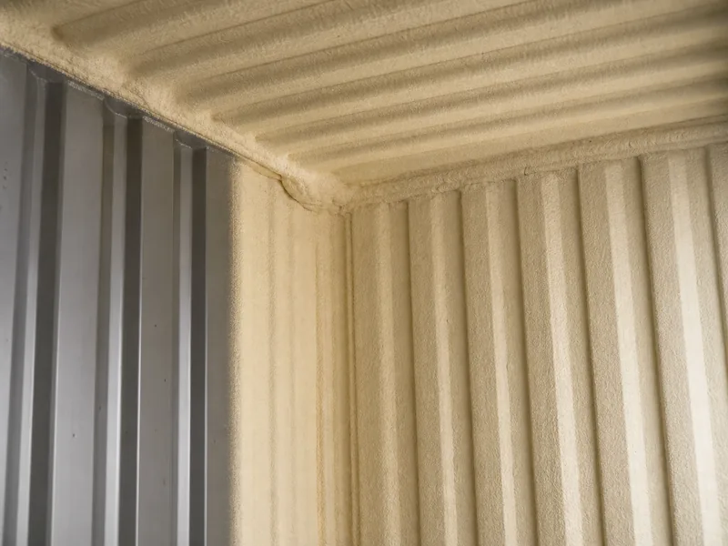 Closed-cell spray foam insulation applied to the interior steel wall of a shipping container to control condensation, a key insulation variable in container building vs steel building
