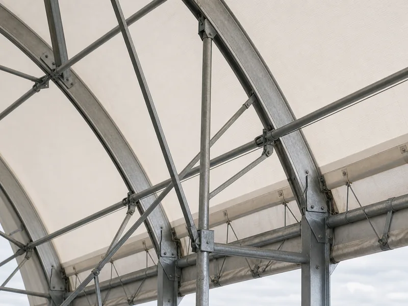 Galvanized steel truss frame under the tensioned fabric roof of a farm building