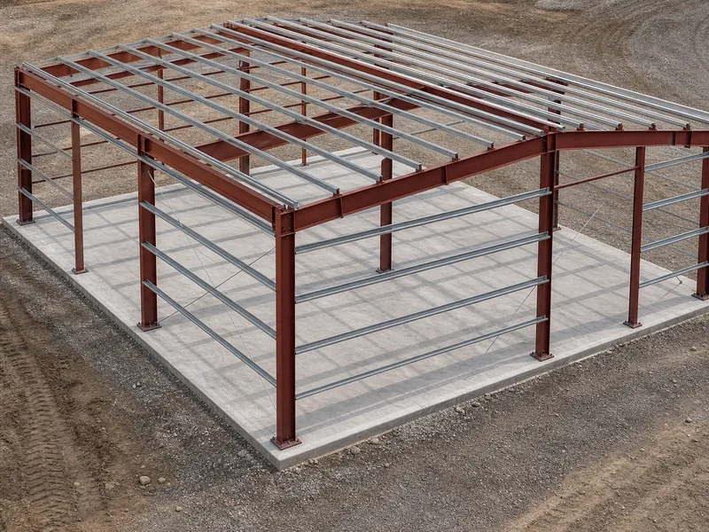 Red iron building frame showing primary I-beam columns and rafters with secondary purlins and girts