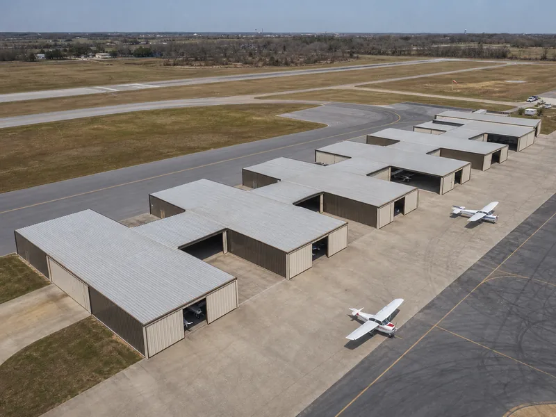 Rangée de hangars en T imbriqués pour un seul avion sur un aéroport d’aviation générale